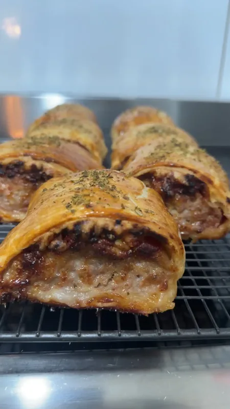 Golden homemade Fat Porkies sausage rolls fresh from the oven cooling on a wire rack