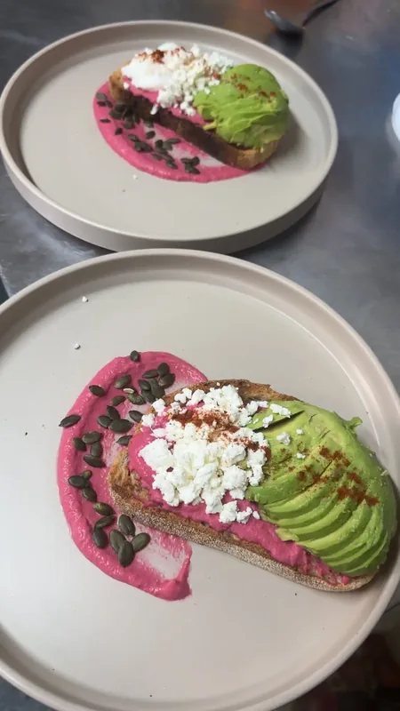 Loaded beetroot hummus on toasted sourdough with sliced avocado and micro-herbs